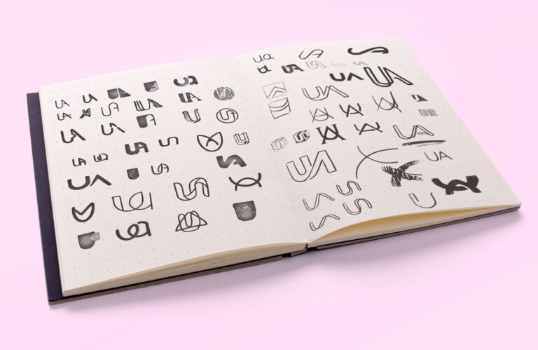 University Alliance Rebrand: a photo of a sketchbook showing some sketches of logo ideas